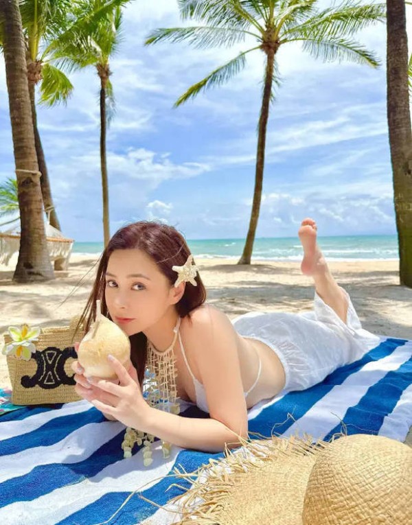 钟欣潼手拿椰子，甜美俏皮。