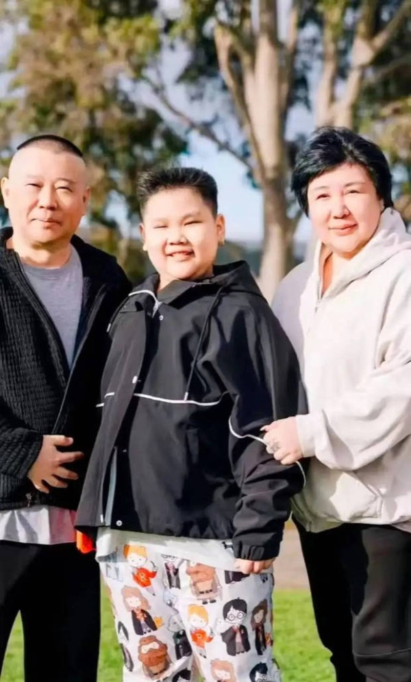 夫妻俩挽着小儿子合影，其乐融融。