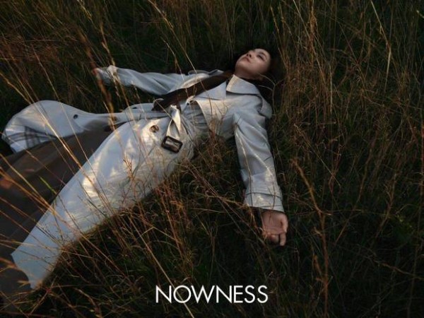 汤唯躺在草地上，慵懒松弛。