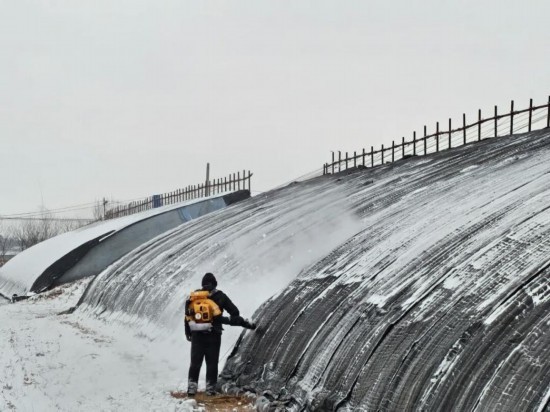 11月27日,在辽宁省铁岭县药王庙村,农户正在清理蔬菜大棚上的积雪。(受访者供图)