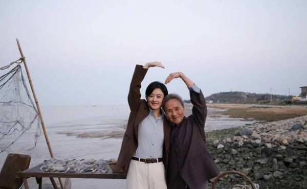 二人抬手比心,笑容灿烂。