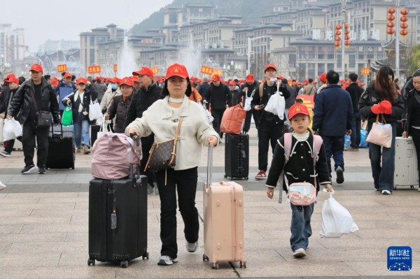 2月22日，乘坐返岗务工专列的务工人员及家属在凯里南站广场准备进站。新华社发（王波摄）