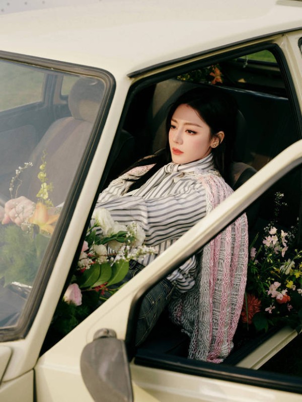 迪丽热巴车内满是鲜花，眼神沉静，松弛文艺。