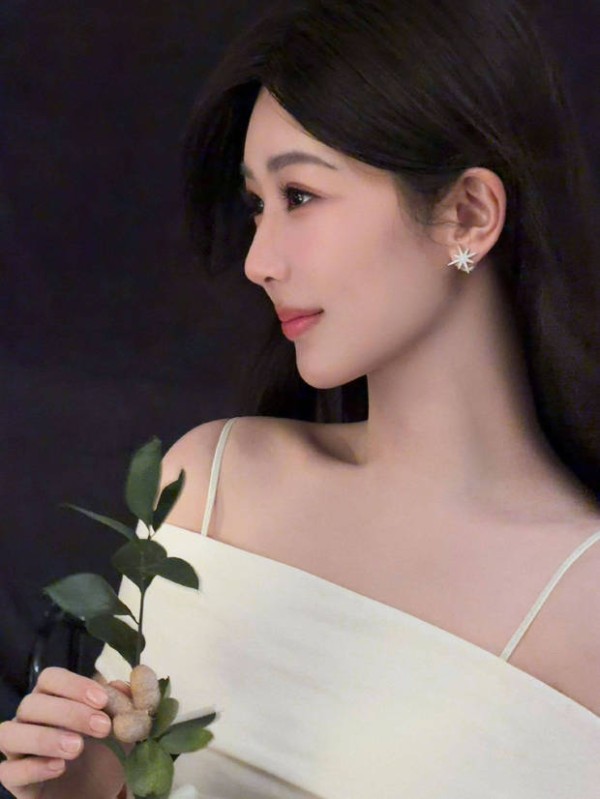 杨紫手持绿植，吊带白裙温柔又清新。