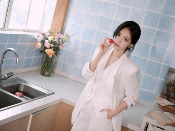 李一桐拈草莓近脸,眼神灵动娇俏。