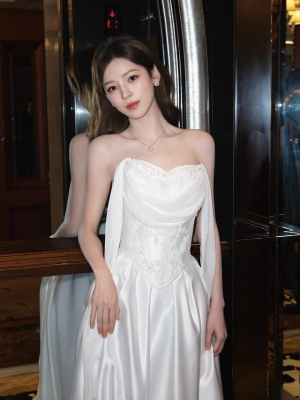 张予曦轻撩发丝眼神温柔，颈间细钻点缀，白裙衬得气质温婉又高级。